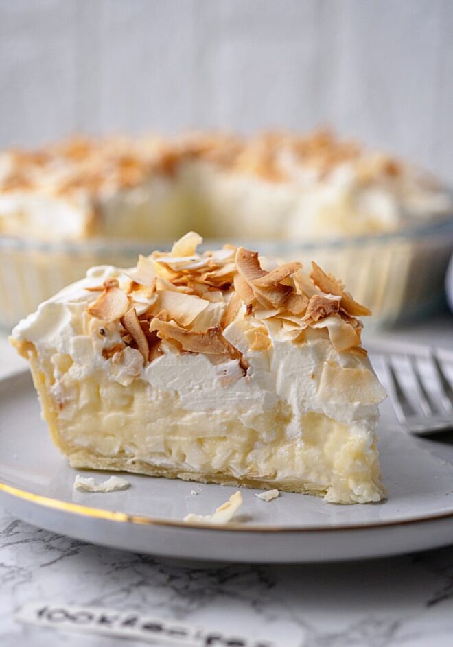 a slice of coconut cream pie topped with toasted coconut