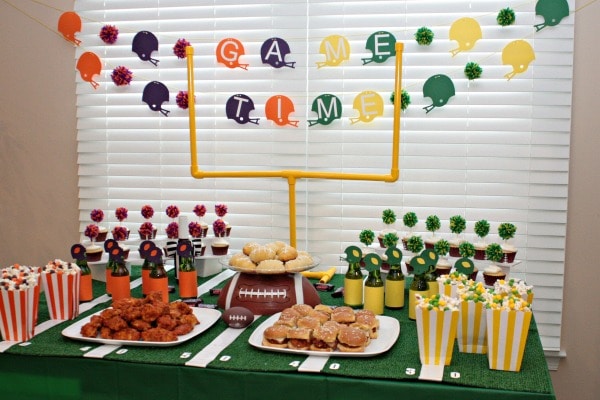 When we can’t make it to the football game for tailgating we bring the party to our living room with a little homegating! We go all out with fun game day decorations and game day recipes. Table goals, snickers crescent rolls, skittles popcorn, and a table that looks like a football field, we are ready to party!