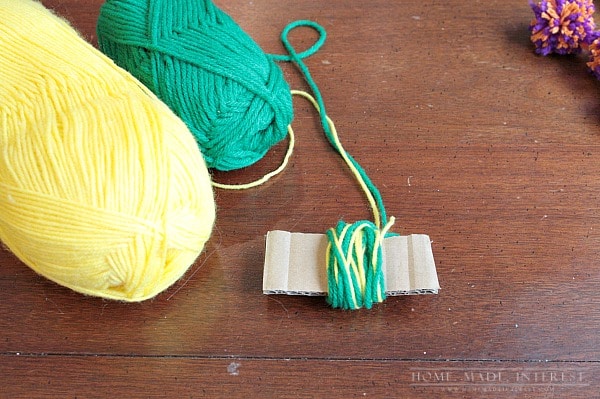 This simple craft tutorial on how to make yarn pom poms will change your life! You’ll want to put yarn pom poms everywhere! They are great for party decorations, garlands and banners, and cupcake toppers! 