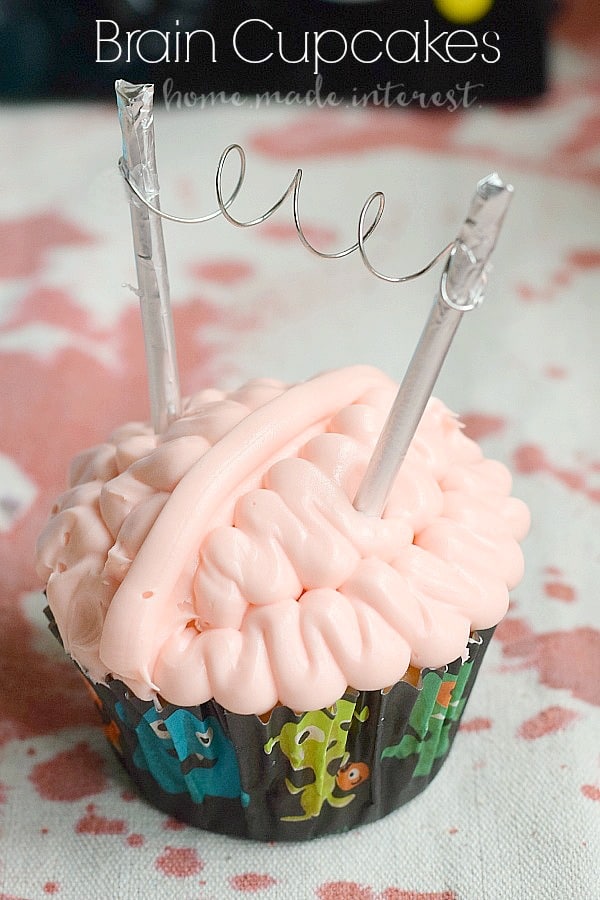 These creepy brain cupcakes are what every mad scientist wants at his Halloween Party. Tutorial for how to frost the cupcakes and a simple DIY Halloween cupcake topper. 