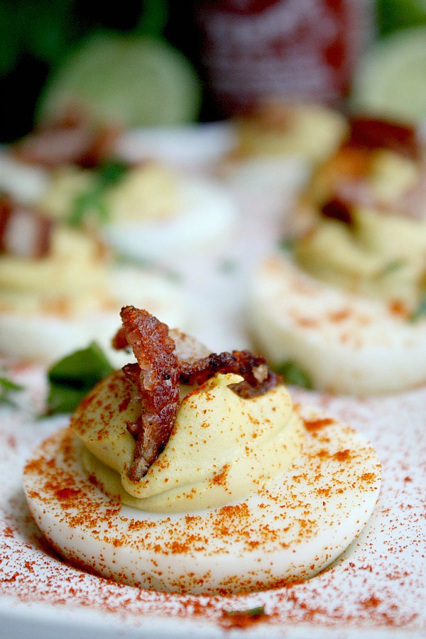 These spicy deviled eggs are a tasty twist on a classic with the zing of Sriracha, the velvety smoothness of avocado, and the saltiness of bacon. Sriracha Bacon and Avocado deviled eggs are low carb and gluten free and make a great party appetizer and Easter dinner and Easter brunch recipe!