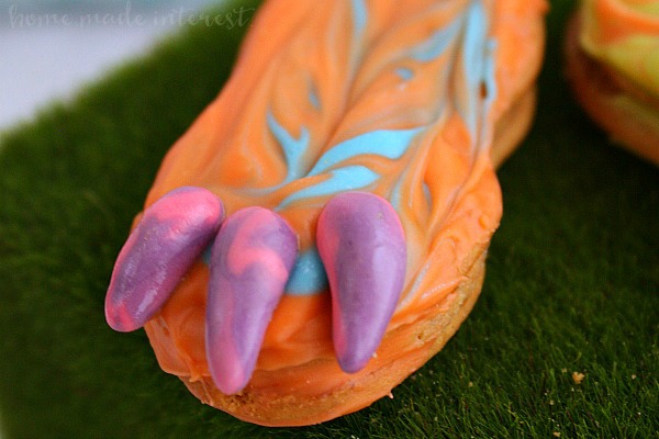 These fun and imaginative Dragon Feet Cookies are an easy dessert recipe for Halloween or a dragon birthday party. These dragon feet are made out of nutter butter cookies coated in multi colored candy melts. I made them for a Pete’s Dragon party everyone loved them. I think they’d make awesome monster feet for a Halloween party!