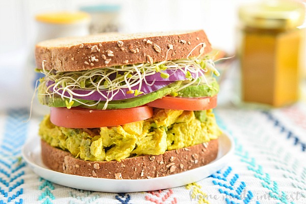 This wholesome sandwich is a healthy lunch recipe that is filled with flavor. The turmeric chicken salad base is mashed with avocados to make a creamy lunch salad that is healthy and full good fats. The avocado turmeric chicken salad is sandwiched between two pieces of sprouted bread for a filling lunch recipe!