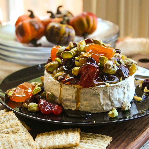 This Dried Fruit and Pistachio Baked Brie is an elegant and delicious appetizer recipe that is perfect for Thanksgiving, Christmas, and New Year’s Eve. The dried fruit and pistachios are coated in a sweet drizzle of honey and placed on top of the melted brie to be served with bread and crackers.