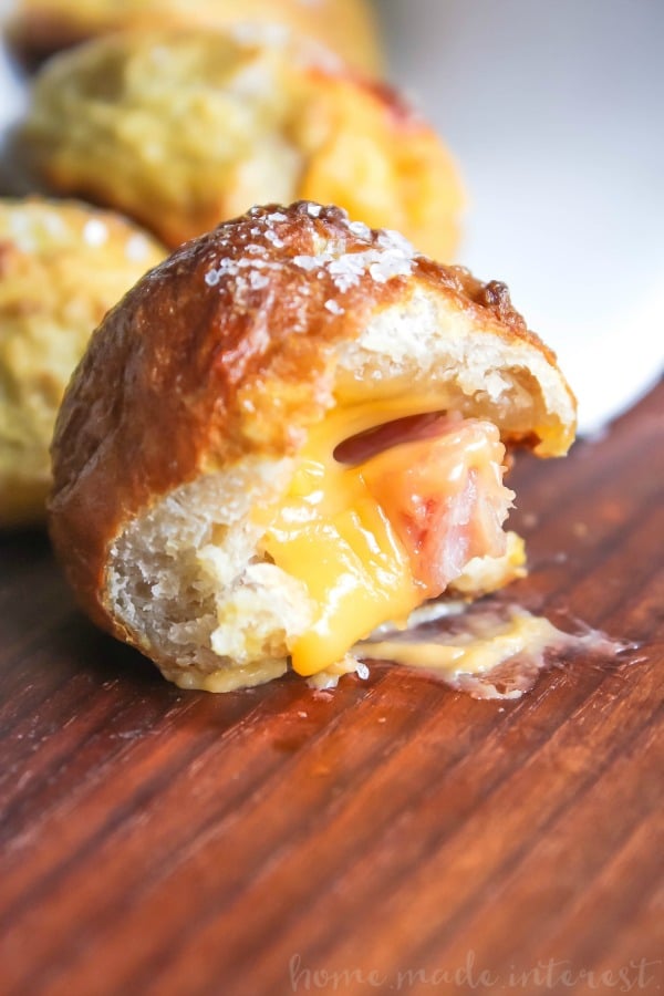 These ham and cheese pretzel bombs are pretzel dough stuffed with cheese and delicious ham. They are an easy appetizer recipe that is a great way to use leftover ham. Ham and cheese pretzel bombs are an easy game day appetizer that are exploding with cheesy goodness!