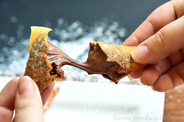 nutella wonton being broken open with chocolate oozing out.