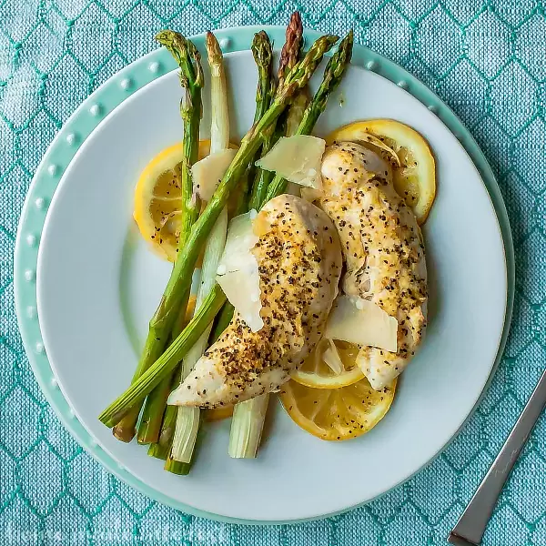 Sheet Pan Lemon Chicken and Asparagus | This easy sheet pan meal is perfect for spring or summer. Bright, fresh asparagus and chicken tenders baked on a sheet pan over lemon slices giving everything a light, fresh flavor. This Sheet Pan Lemon Chicken and Asparagus is a quick and easy weeknight dinner recipe that is great if you are looking for healthy dinner recipes.
