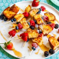Lemon poundcake french toast skewers on a white plate with powdered sugar