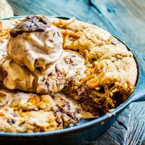 Salted Caramel Chocolate Skillet Cookie | This skillet cookie recipe is a chocolate chip cookie filled with rich creamy caramel, white chocolate chips, and salty, crunchy pretzels. It’s baked in a cast iron skillet until everything melts together into a decadent cookie dessert topped with a couple of scoops of ice cream. This cast iron skillet dessert is an easy dessert recipe that the whole family will love.