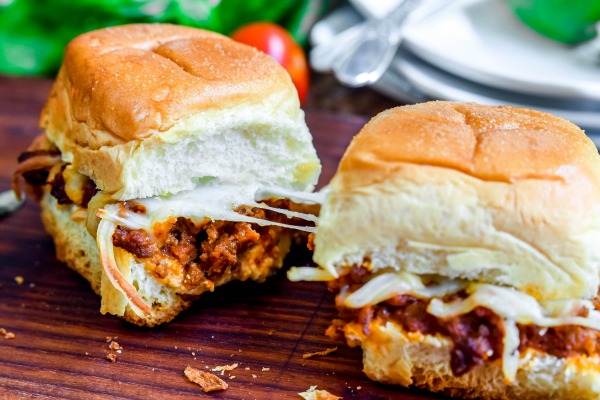 Lasagna sliders together with cheese stretching between them.