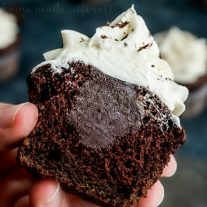 triple chocolate cupcake cut in half with ganche filling showing.