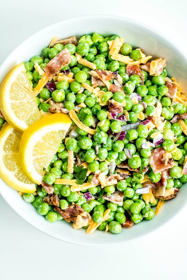A large white bowl filled with Creamy Bacon Pea Salad
