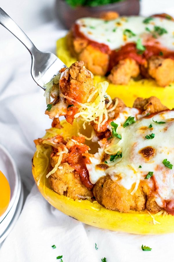 Fork taking a bite of chicken parmesan roasted spaghetti squash