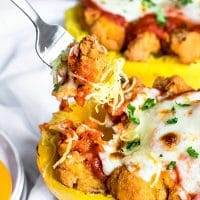 A fork digging into chicken parmesan roasted spaghetti squash