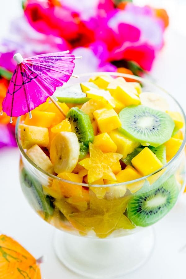 Pina Colada Tropical Fruit Salad served in a large glass bowl with a drink umbrella