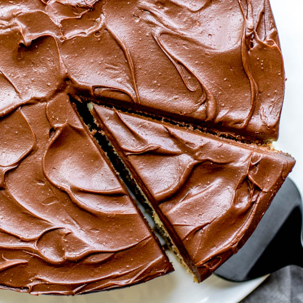 a slice of yellow butter cake with chocolate frosting