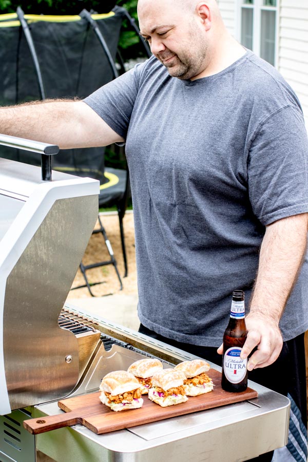 man outside with BBQ Jackfruit Sliders and beer