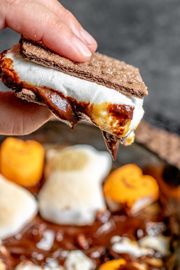 holding s'more made with Halloween S'mores Dip