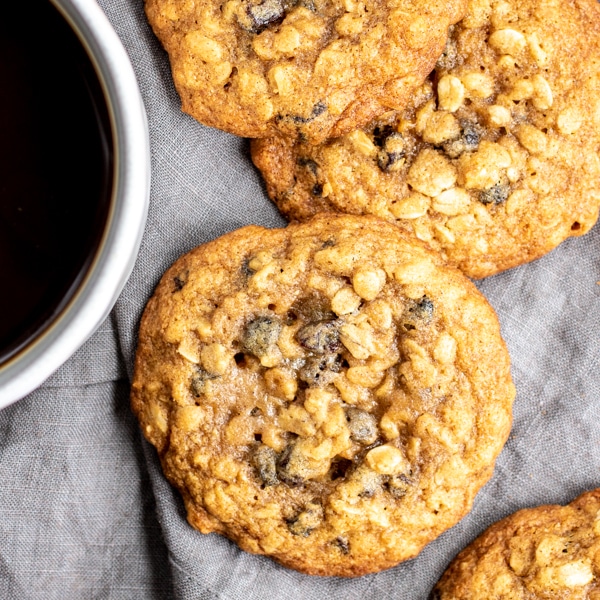 oatmeal raisin cookies sitting next to a cup of coffee