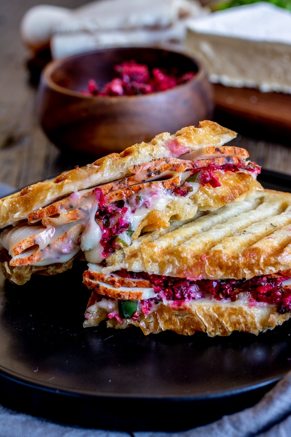 Turkey and cranberry panini on a black plate