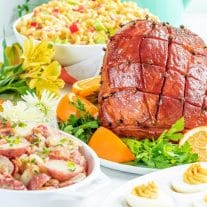 Honey glazes ham on a table with sides