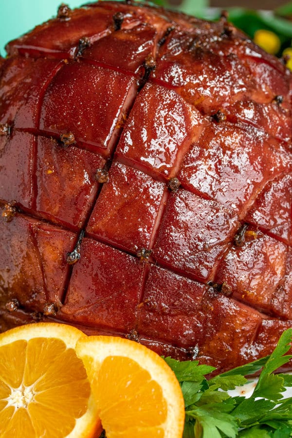 A beautiful honey glazed ham studded with cloves and glistening with a baked on glaze