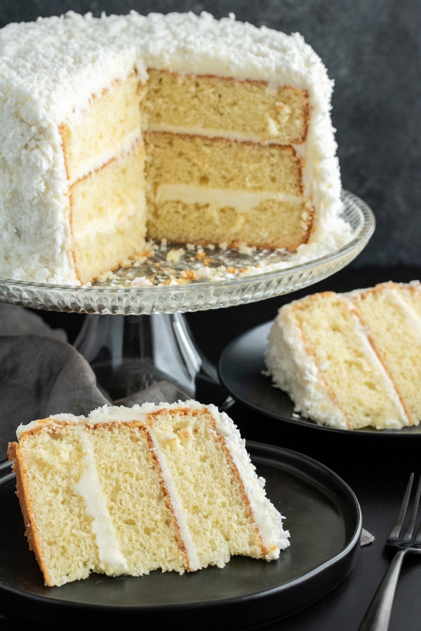 Coconut cake with two slices of cake cut and on plates