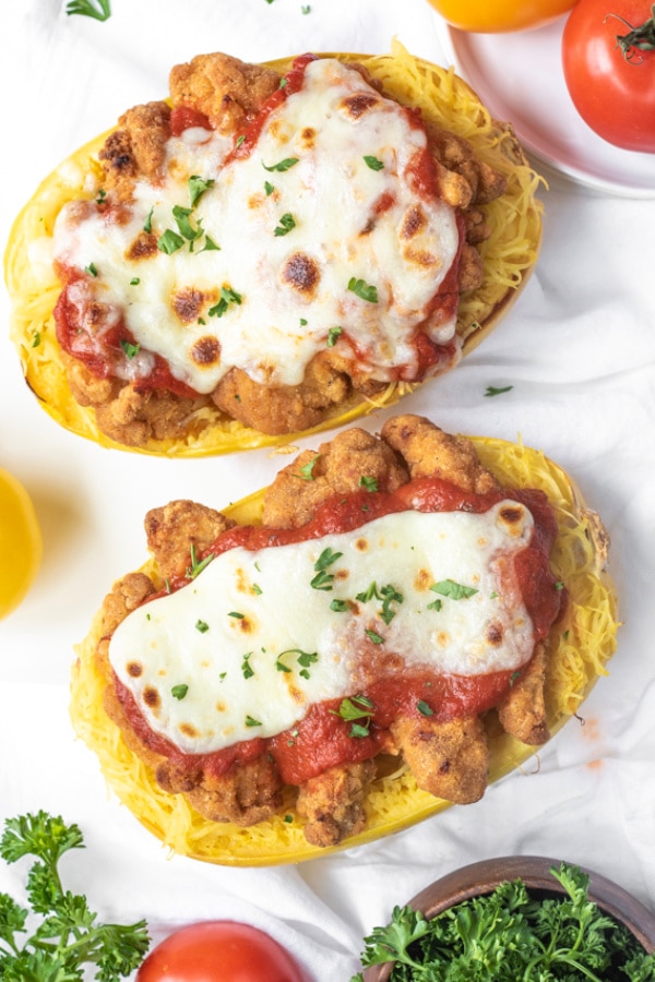 Top halves of roasted spaghetti squash topped with chicken parmesan