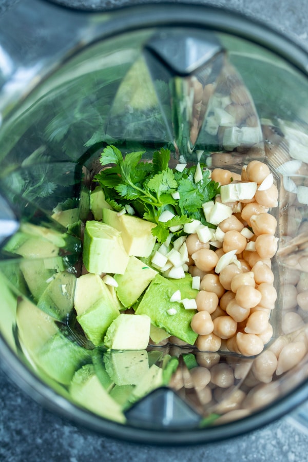 All of the ingredients for avocado hummus in a blender