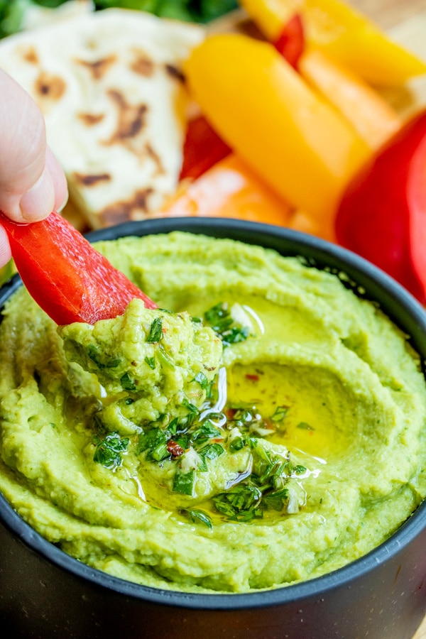 Red Pepper slice scooping up some avocado hummus