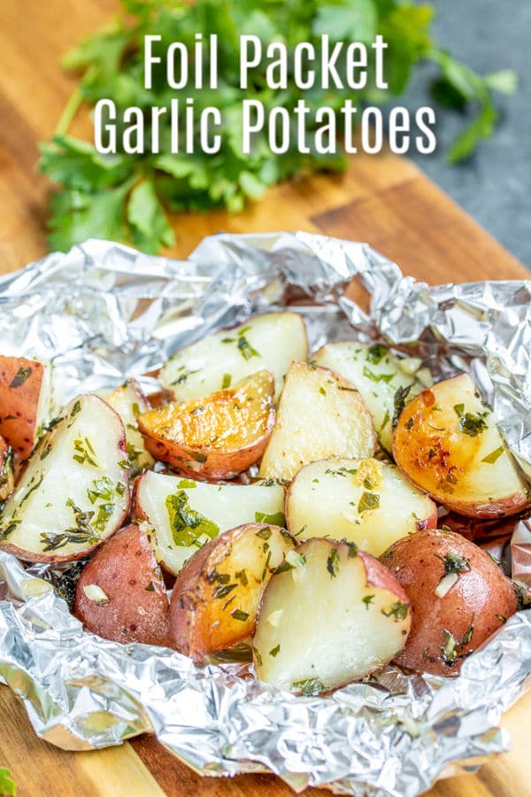 These easy Foil Packet Garlic Potatoes are cooked on the grill or in the oven with lots garlic and herbs for a perfectly tender roasted potatoes recipe packed with flavor. Make them as a side with your grilled steak or serve them along with roasted chicken for an easy grilled side dish. #homemadeinterest #potatoes #garlic #grilled #foilpacket