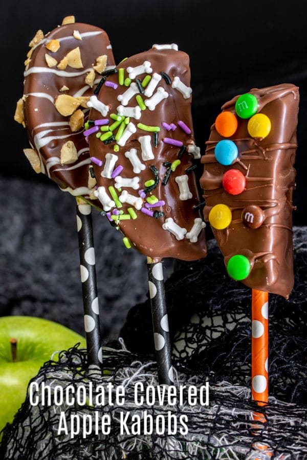 These Chocolate Covered Apple Kabobs are an easy idea for your Halloween party. Chocolate covered apple slices on a stick make serving candied apples super easy. Decorate them with dark chocolate, milk chocolate, and white chocolate, and top with your favorite candies. It's a fun fall dessert or Halloween dessert recipe. #dessert #apple #chocolate #halloweenrecipes #halloweenparty #homemadeinterest