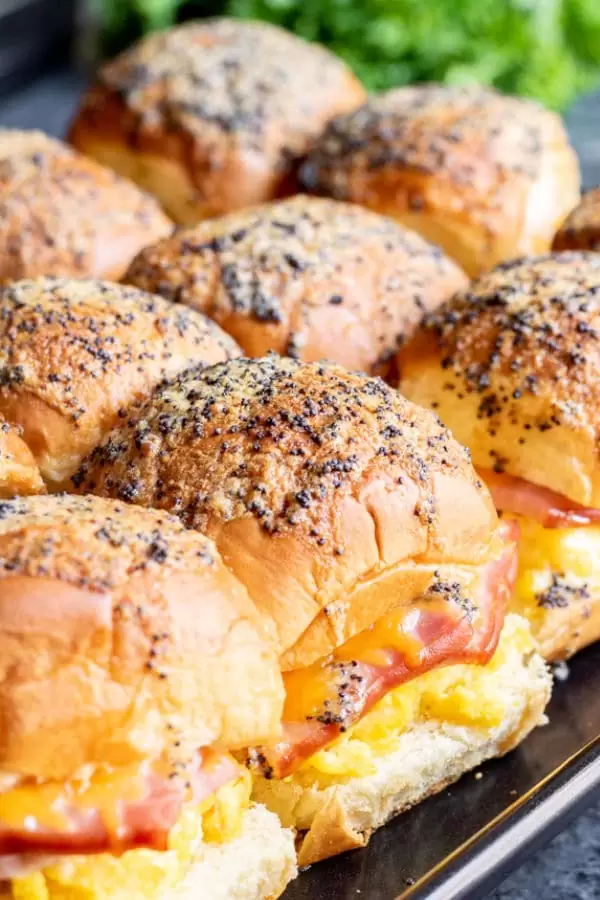 Ham Egg and Cheese BReakfast Sliders lined up together on a baking sheet