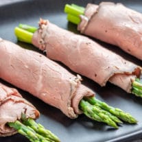 Roast Beef and Asparagus Roll Ups on a black platter