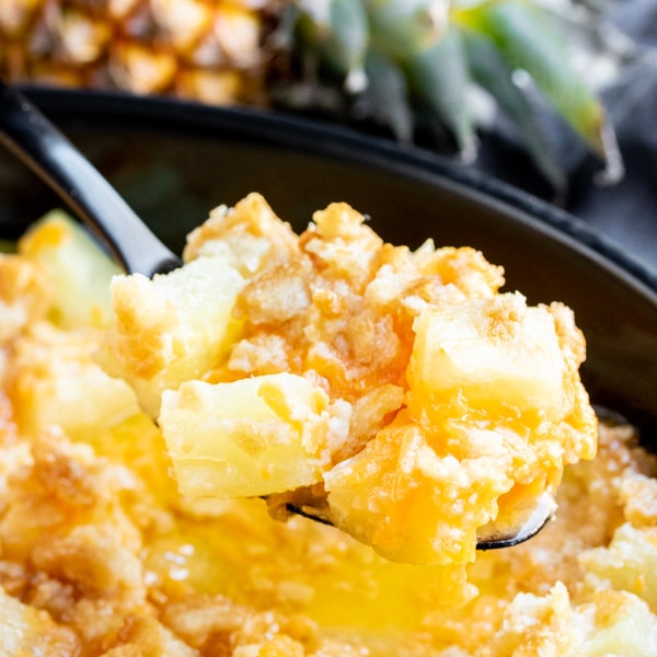 Serving a scoop of baked pineapple casserole