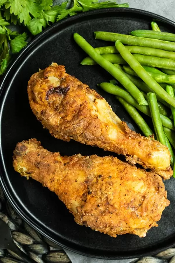 Top down shot of Air Fryer Fried Chicken on a plate with green beans