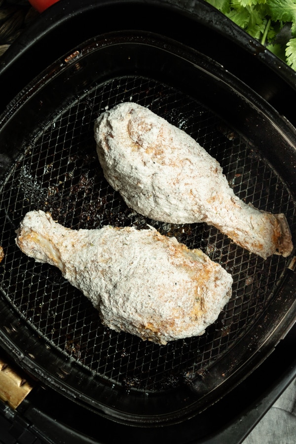 Raw chicken coated in flour and placed in the air fryer