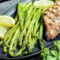 Air Fryer Asparagus on a black plate with chicken