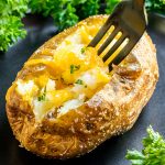 Air Fryer Baked Potato with fork and cheese