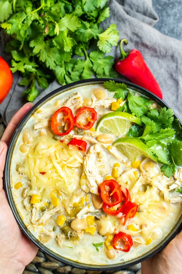 holding a bowl of Instant Pot White Chicken Chili