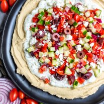 5 Layer Greek Dip on a plate with feta
