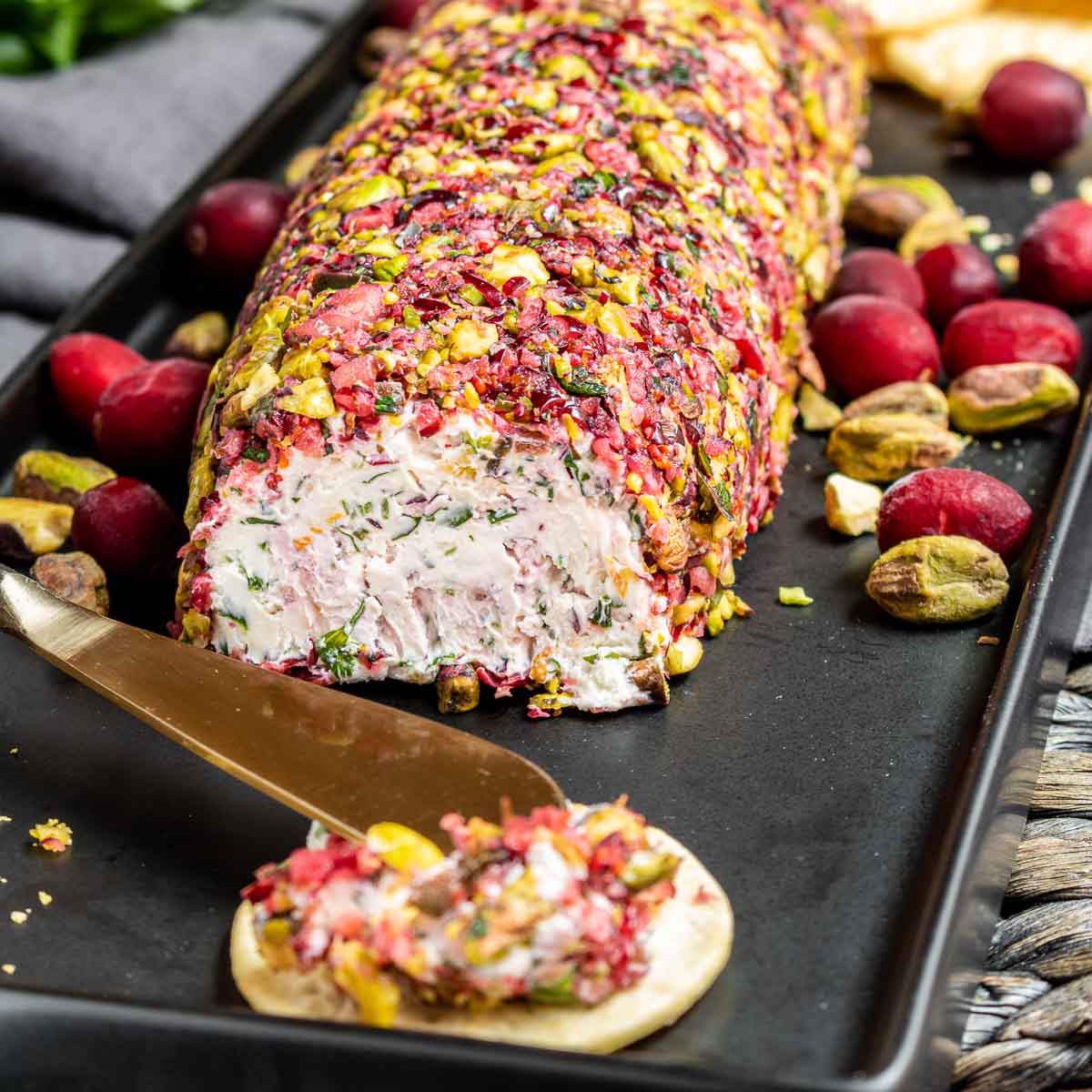 Goat Cheese Log on black platter with cranberries
