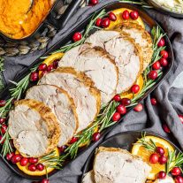 platter of Instant Pot Turkey Breast garnished with orange slices and fresh cranberries
