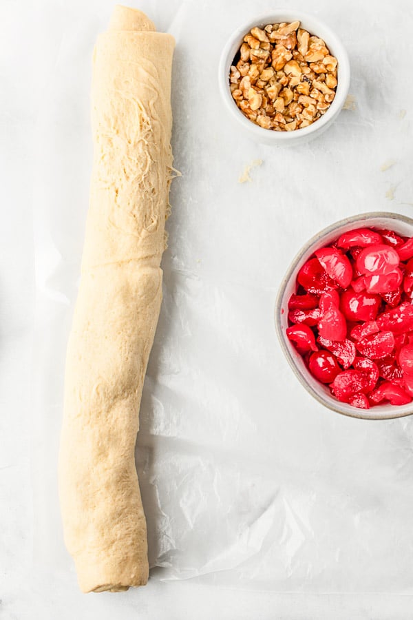 rolled up dough with maraschino cherries and chopped nuts to make Holiday Crescent Ring