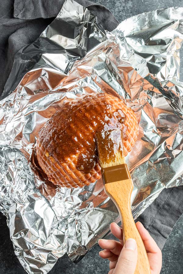 brushing Instant Pot Ham with brown sugar on foil