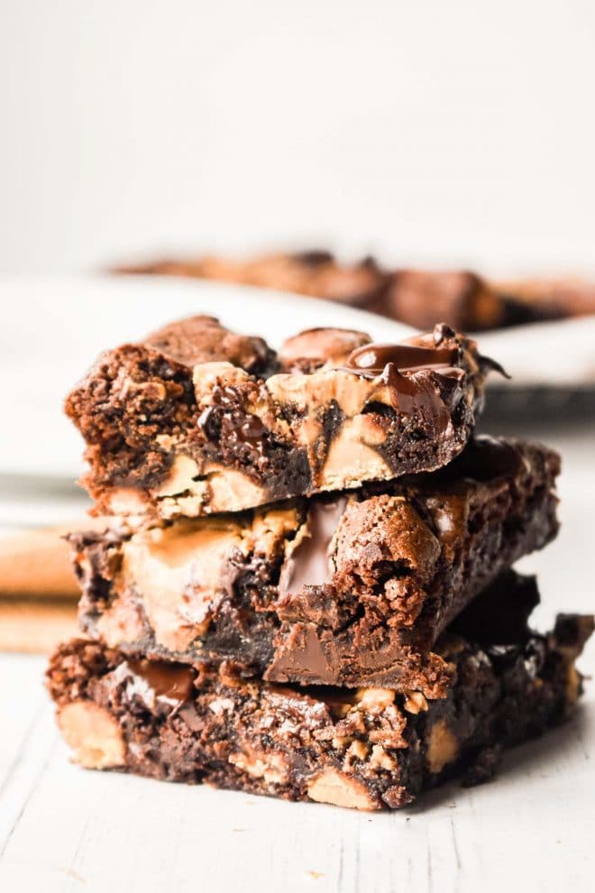 Dark Chocolate Peanut Butter Brownies stacked on white board