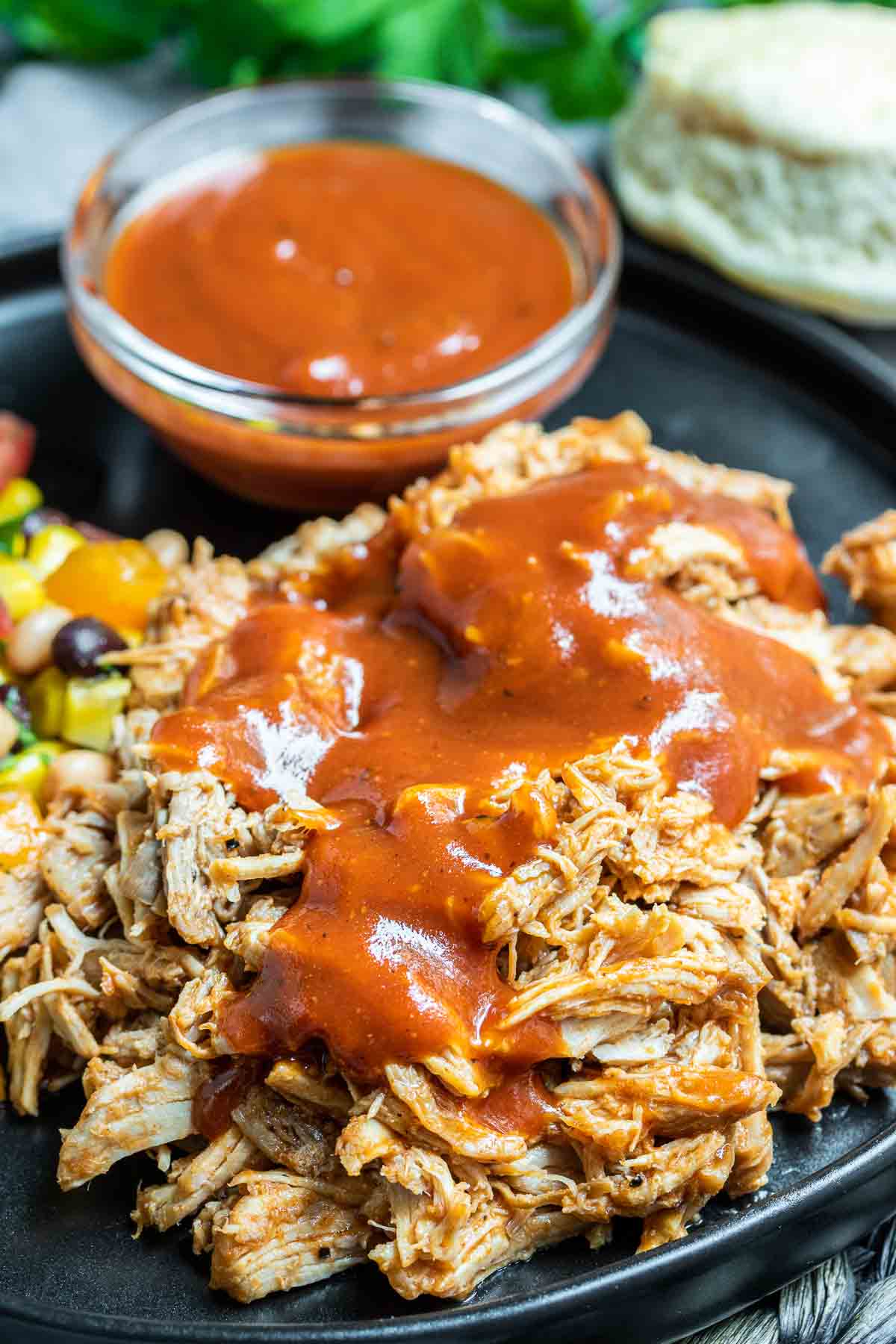 Pressure Cooker Pulled Pork on a plate with BBQ sauce on the background