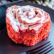 Red Velvet Cinnamon Rolls with cream cheese glaze on a plate