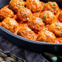 Air Fryer Meatballs in a black patter with tomato sauce