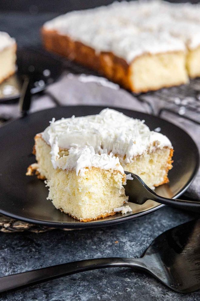 piece of Coconut Sheet Cake on a plate with a fork